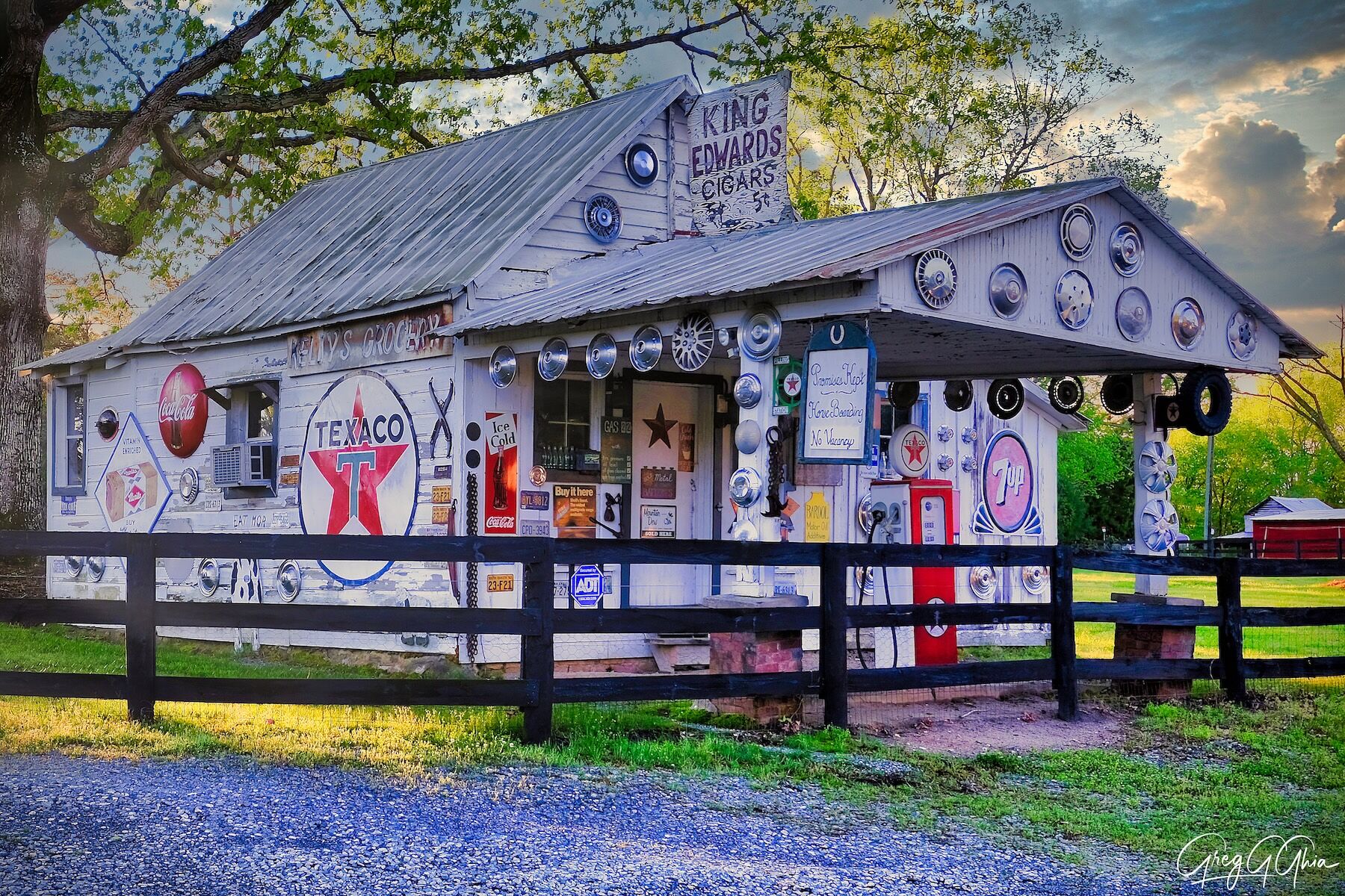 A small, local grocery store with vintage signs and logos sits along a gravel road in Cary, North Carolina. 